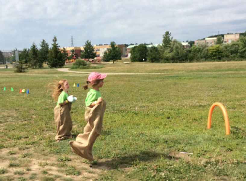 two girls racing in a potato bag race